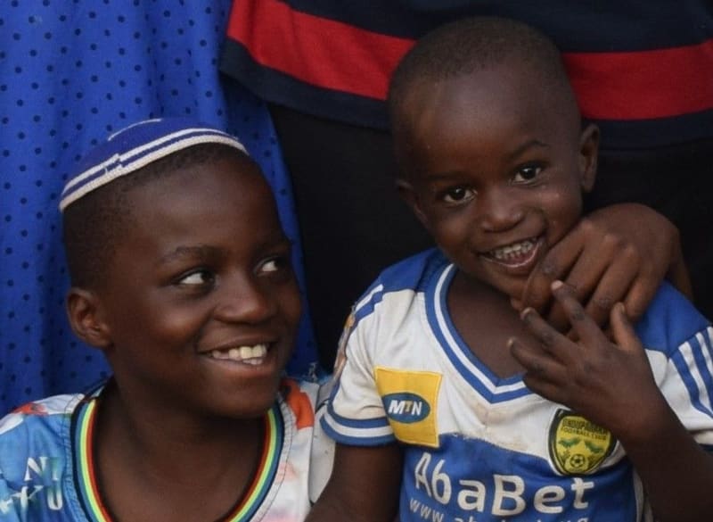 Two smiling boys, one of them wearing a kippah.